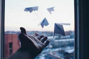 A man's hand launches paper aeroplanes representing Workday Go-Live